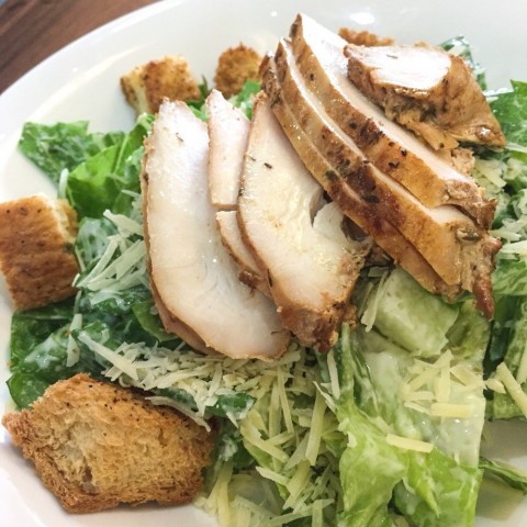 Caesar salad with baked chicken , crunchy romaine lettuce , Parmesan and croutons 