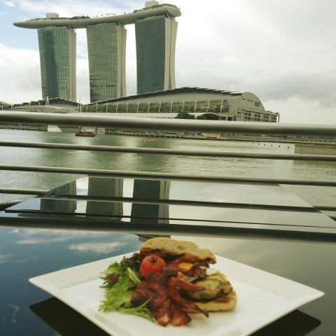 Enjoying the delicious crispy bacon with tender grilled chicken breast with a beautiful view of Marina Bay 