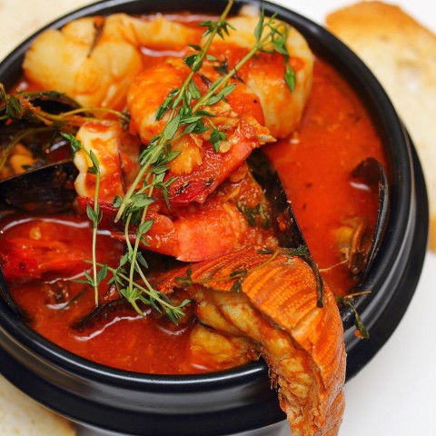 A comforting bowl of tomato based sauce brimming with mussels, shelled prawns, squid, clams. crayfish and cod. Slices of home baked bread are served on the side to sop up all the tasty, saucy goodness