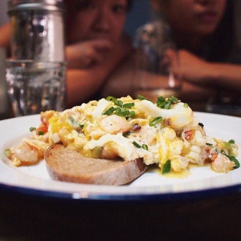 Scrambled eggs with prawns, roasted garlic and spring onions on toast! 
